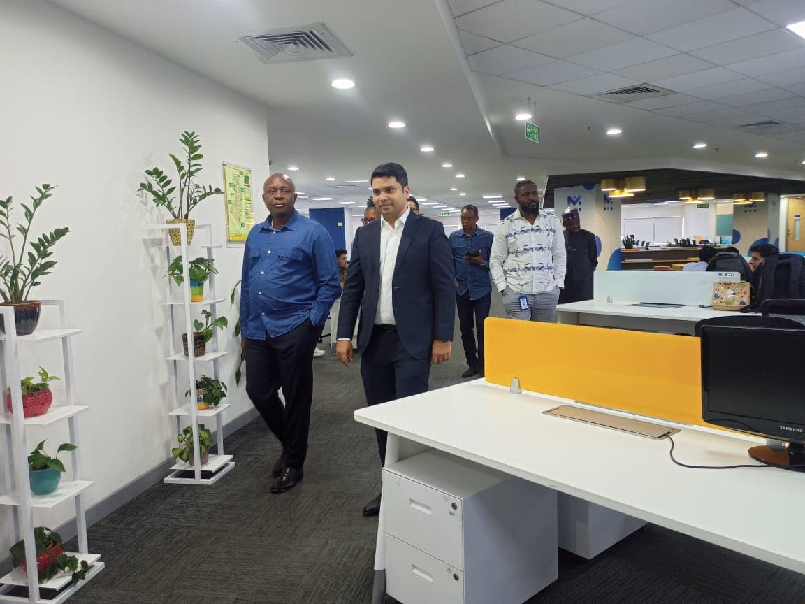 Delegates walking past planted display stands on the engineering floor