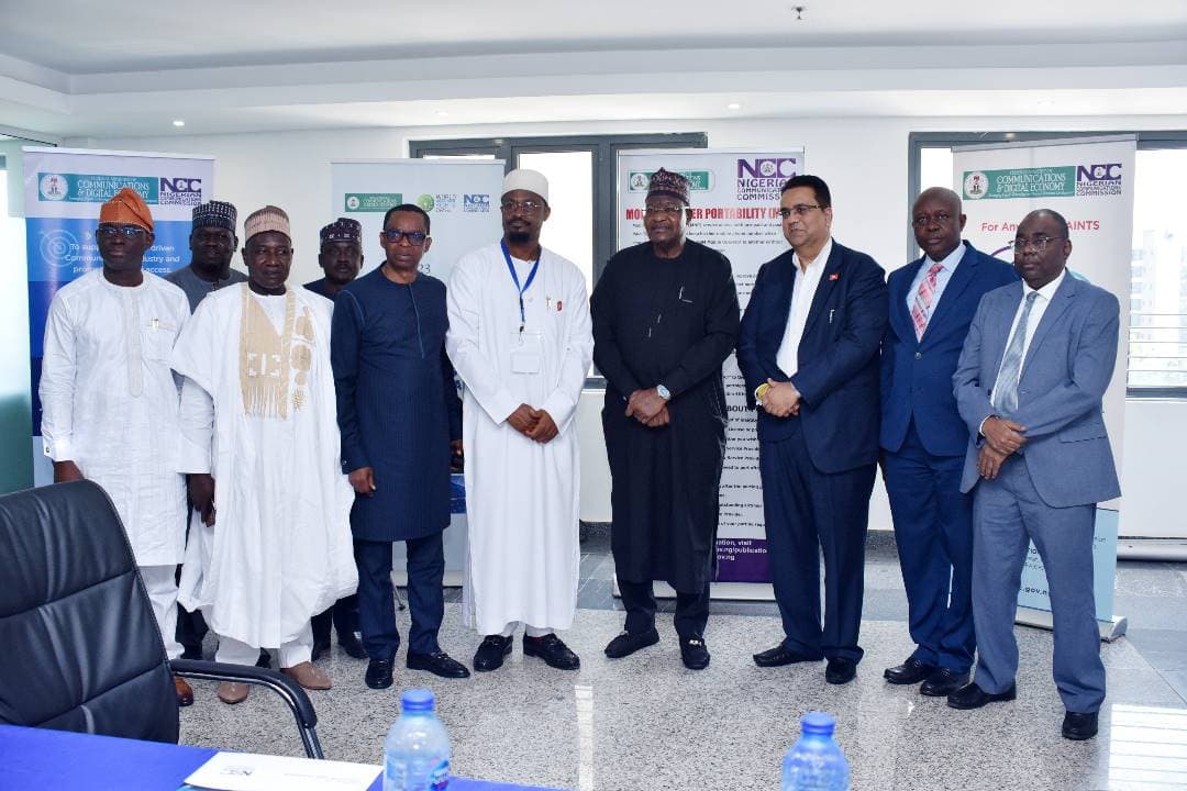 NCC officials in traditional attire and 3R Consortium representatives posing in front of NCC banners