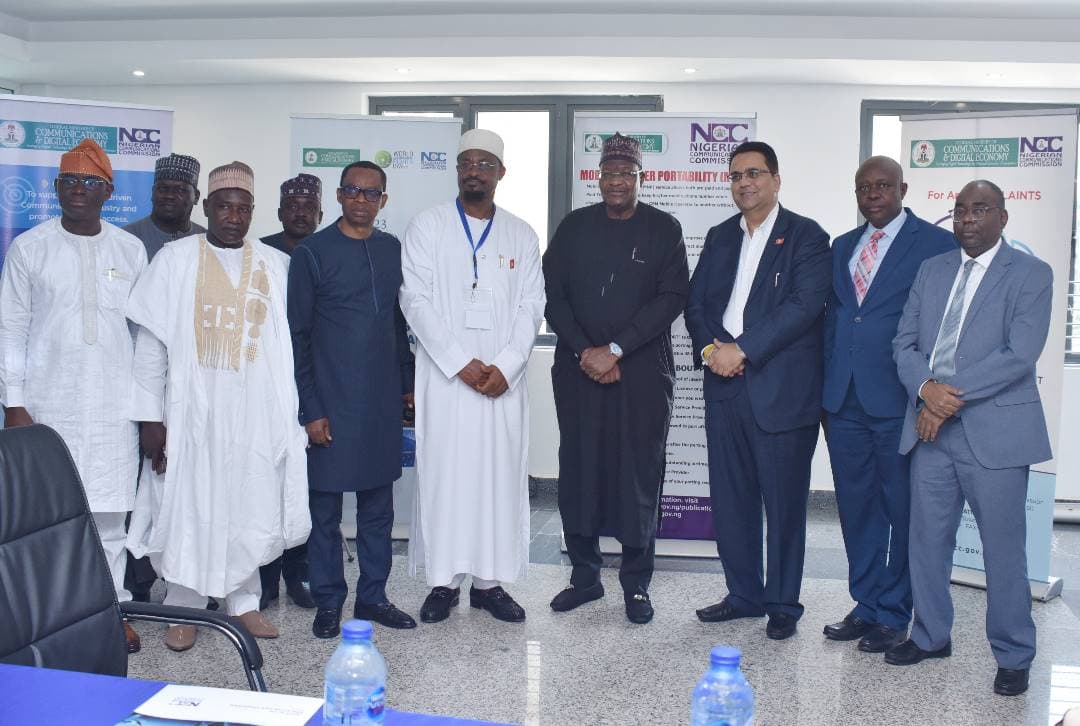 A second group portrait of NCC and 3R Consortium delegates in front of NCC banners