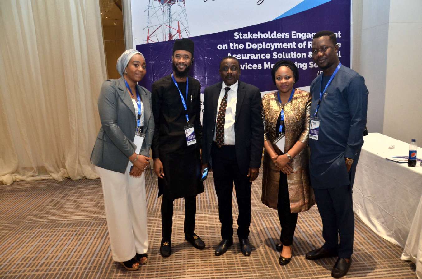 Five delegates posing in front of the Stakeholders Engagement event backdrop