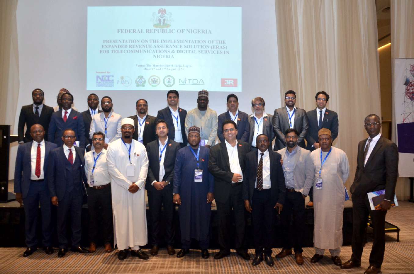 The full delegation posing beneath a Federal Republic of Nigeria briefing slide on the ERAS Project's implementation
